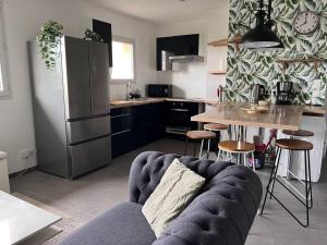 a kitchen with a couch in a kitchen with a refrigerator at Magnifique Duplex Choisy le roi avec parking in Choisy-le-Roi