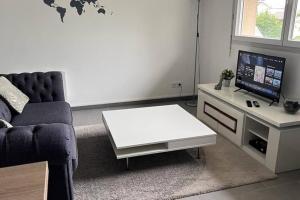 ein Wohnzimmer mit einem Sofa und einem weißen Couchtisch in der Unterkunft Magnifique Duplex Choisy le roi avec parking in Choisy-le-Roi