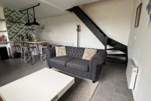 ein Wohnzimmer mit einem Sofa und einem Tisch in der Unterkunft Magnifique Duplex Choisy le roi avec parking in Choisy-le-Roi