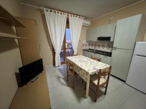 eine Küche mit einem Tisch mit Stühlen und einem Kühlschrank in der Unterkunft Hotel Acquario in Campomarino