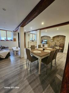 a dining room and living room with a table and chairs at Ferienwohnung ,,Hinter der Mauer'' in Hildburghausen