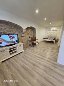 a living room with a flat screen tv and a couch at Ferienwohnung ,,Hinter der Mauer'' in Hildburghausen