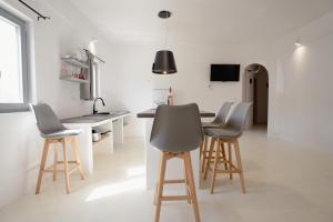 a kitchen with a table and four stools at Saint Barbara luxury home in Dhragoulás