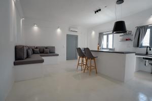 a kitchen and living room with a counter and chairs at Saint Barbara luxury home in Dhragoulás