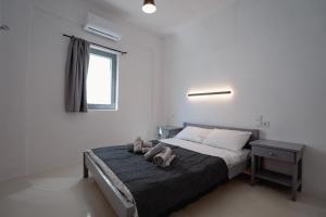 a bedroom with a bed with two shoes on it at Saint Barbara luxury home in Dhragoulás +29 photos