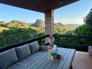 a porch with a couch and a table with wine glasses at Casa Paradiso in Costa Paradiso