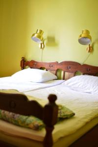 a bed with a wooden headboard with two lights on it at Piece of Hjo Vandrarhem in Hjo