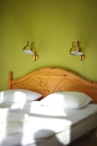 um quarto com uma cama de madeira e 2 luzes por cima. em Piece of Hjo Vandrarhem em Hjo