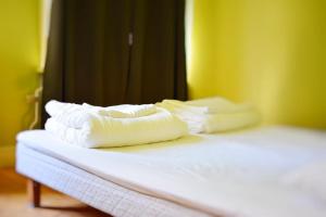 two stacks of white towels sitting on top of a bed at Piece of Hjo Vandrarhem in Hjo