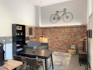 un salon avec un vélo suspendu sur un mur de briques dans l'établissement Großzügiges Studio-Apartment - Top-Lage + Parken, à Nuremberg