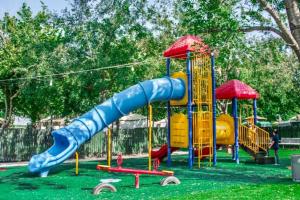 a playground with a blue slide in the grass at לארח, זה בטבע שלנו in Kfar Blum