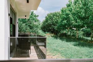 a glass balcony with a chair on a house at B&B Lovac Hasa 2 in Ulcinj