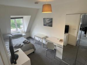 a bedroom with a bed and a desk and a mirror at 2 Bedroom 2 bathroom Apartment 8 including free parking in Bromley