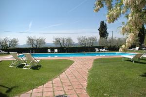 uma piscina com duas cadeiras num quintal em La Casa Delle Querce em Acquaviva