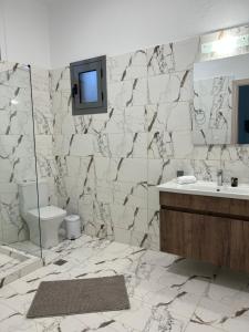 a bathroom with a sink and a tv on the wall at Paola’s apartments near Athens Airport in Spáta