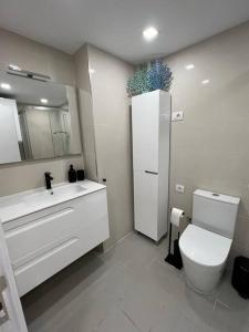 ein Badezimmer mit einem WC, einem Waschbecken und einem Spiegel in der Unterkunft Apartamento Primera línea playa in Las Palmas de Gran Canaria