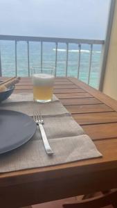 einen Tisch mit einem Glas Orangensaft und einer Gabel in der Unterkunft Apartamento Primera línea playa in Las Palmas de Gran Canaria