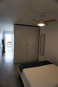 Schlafzimmer mit einem Bett und einem Deckenventilator in der Unterkunft Apartamento Primera línea playa in Las Palmas de Gran Canaria