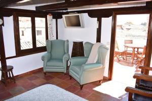 two chairs and a television in a living room at 15th Century Palace with Beautiful Private Terrace in Toledo