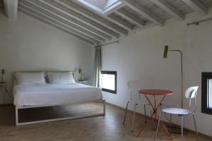 a bedroom with a bed and a table and chairs at Corte LOIOL in Scorzarolo
