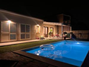 ein Schwimmbad vor einem Haus in der Nacht in der Unterkunft Villa Theoma in Castelnuovo Magra