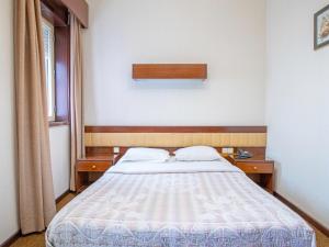 a bedroom with a bed and two tables and a window at Porto Je T'aime - Solar São João in São João da Madeira