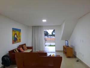 a living room with a couch and a tv at Casa do Mutá in Porto Seguro