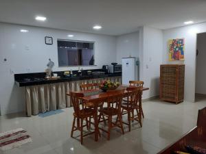a kitchen with a table and chairs and a refrigerator at Casa do Mutá in Porto Seguro