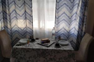 a table with two plates of food and a window at Κεντρικό στούντιο στην Καρδίτσα. in Kardítsa