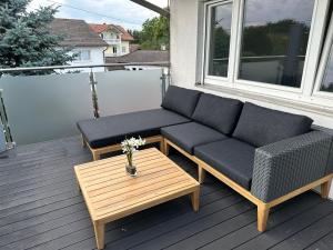 un sofá y una mesa de centro en el balcón en Traumhaftes Zuhause!, en Forstinning