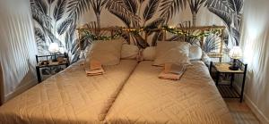 a large bed in a bedroom with two night stands at L 'EDELWEISS de 1 a 9 personnes in Nerpol-et-Serres