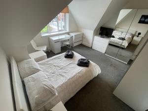 a bedroom with a bed with two black bags on it at 2 Bedroom 2 bathroom Apartment 8 including free parking in Bromley