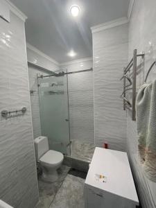 y baño con ducha, aseo y lavamanos. en ЖК Lotus terrace en Almaty