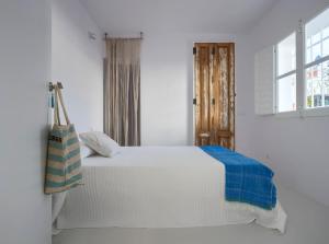 een wit bed in een witte kamer met een raam bij Casa Blu Marbella in Marbella
