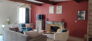 sala de estar con paredes rojas y chimenea en Mas du Vieux Moulin, en Sérignan-du-Comtat