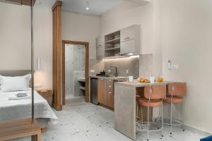a bedroom with a bed and a kitchen with a counter at Phaos Residence, Your Stylish Crete Retreat in Panormos Rethymno