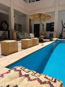 uma piscina com cadeiras e um guarda-sol em Le Patio Du Lac em Lalla Takerkoust