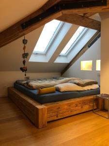 a large bed in a room with skylights at Loft im Haus mit Geschichte in Mähring