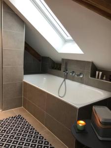 a bathroom with a large bath tub with a skylight at Loft im Haus mit Geschichte in Mähring