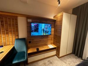 a room with a desk with a television and a chair at Dana Apartmani in Kopaonik