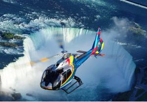 a helicopter flying in front of a waterfall at Luxury 2BDR Suite Mins To Falls in Niagara Falls
