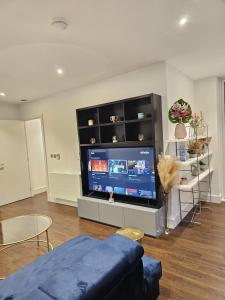 sala de estar con TV de pantalla plana grande en 2 bed Luxurious apartments Canary Wharf en Londres
