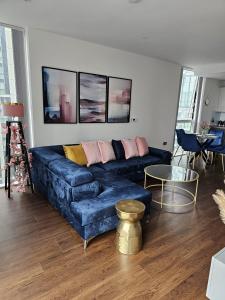 sala de estar con sofá azul y mesa en 2 bed Luxurious apartments Canary Wharf en Londres