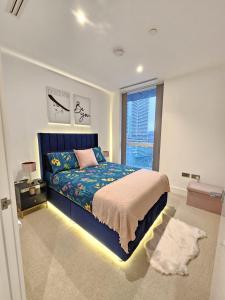 1 dormitorio con cama y ventana grande en 2 bed Luxurious apartments Canary Wharf en Londres