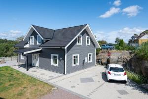 een zwart huis met een auto ervoor geparkeerd bij The Rose Valley in Göteborg