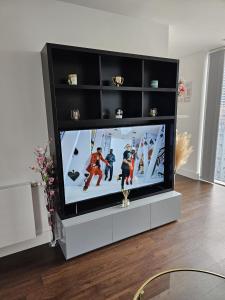 Una televisión o centro de entretenimiento en 2 bed Luxurious apartments Canary Wharf
