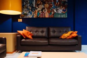 a living room with a brown couch and a blue wall at Cris Hotel in Florianópolis
