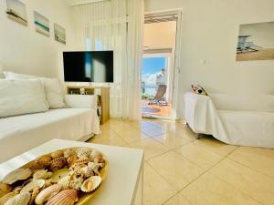 una sala de estar con una mesa con un tazón de conchas en Balaton BeachSide Apartman Siófok N2, en Siófok