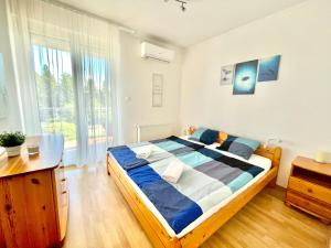 1 dormitorio con cama, escritorio y ventana en Balaton BeachSide Apartman Siófok N2, en Siófok