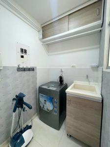 uma pequena cozinha com um lavatório e uma máquina de lavar roupa em CB Apto cómodo e impecable con Aire Acondicionado em Neiva